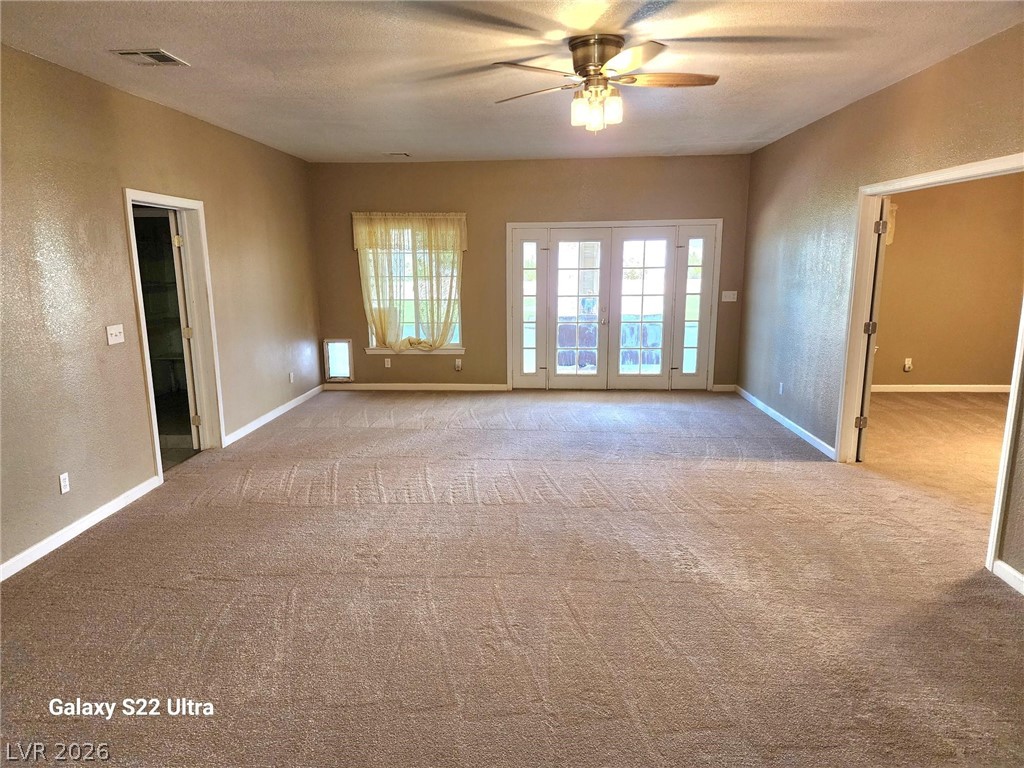1101 East Blosser Ranch Road Pahrump, NV 89060 - Photo 12 of 50 family / Living / Great Room featuring a textured wall, a ceiling fan, light carpet, and a textured ceiling