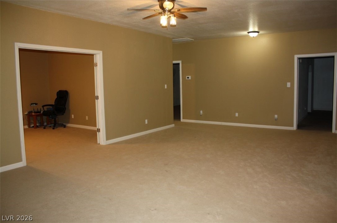 1101 East Blosser Ranch Road Pahrump, NV 89060 - Photo 13 of 50 Unfurnished Living / Family room with ceiling fan, light colored carpet, and an office area
