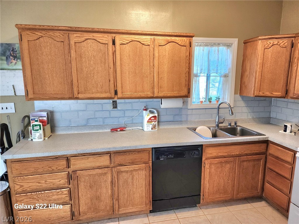 1101 East Blosser Ranch Road Pahrump, NV 89060 - Photo 3 of 50 Kitchen featuring black dishwasher, light countertops, wood finish cabinetry, and light tile patterned floors