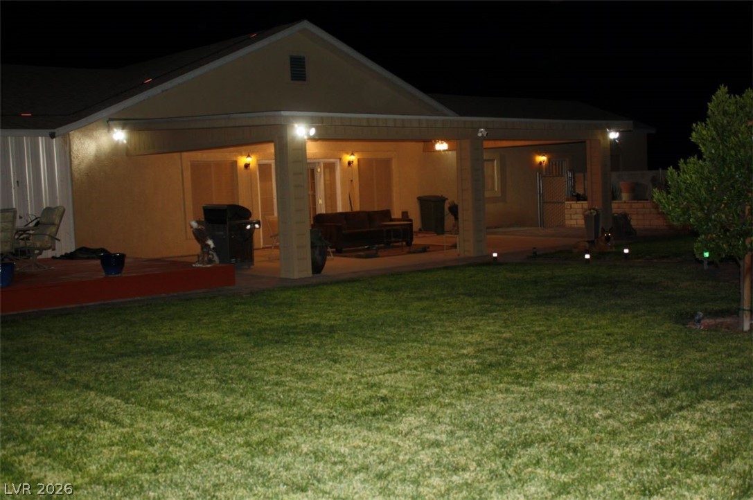 1101 East Blosser Ranch Road Pahrump, NV 89060 - Photo 34 of 50 Back of house at night featuring a yard