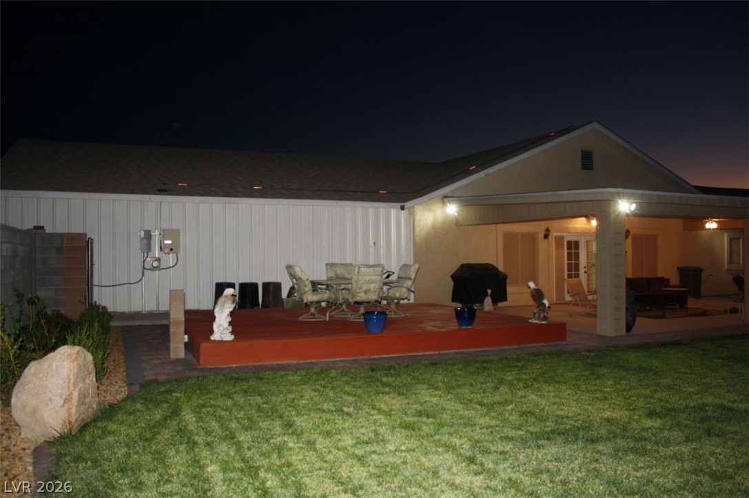 1101 East Blosser Ranch Road Pahrump, NV 89060 - Photo 35 of 50 Back of house at twilight with outdoor dining space, a yard, and a patio