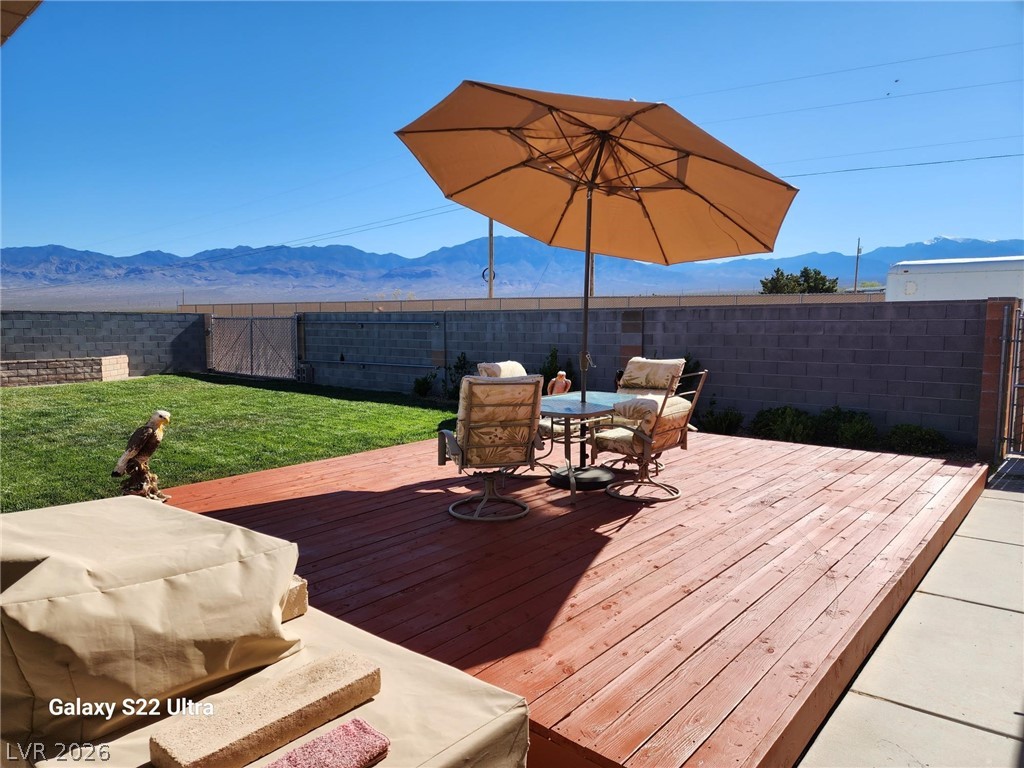 1101 East Blosser Ranch Road Pahrump, NV 89060 - Photo 43 of 50 Wooden deck featuring a mountain view, a fenced backyard, and outdoor dining area