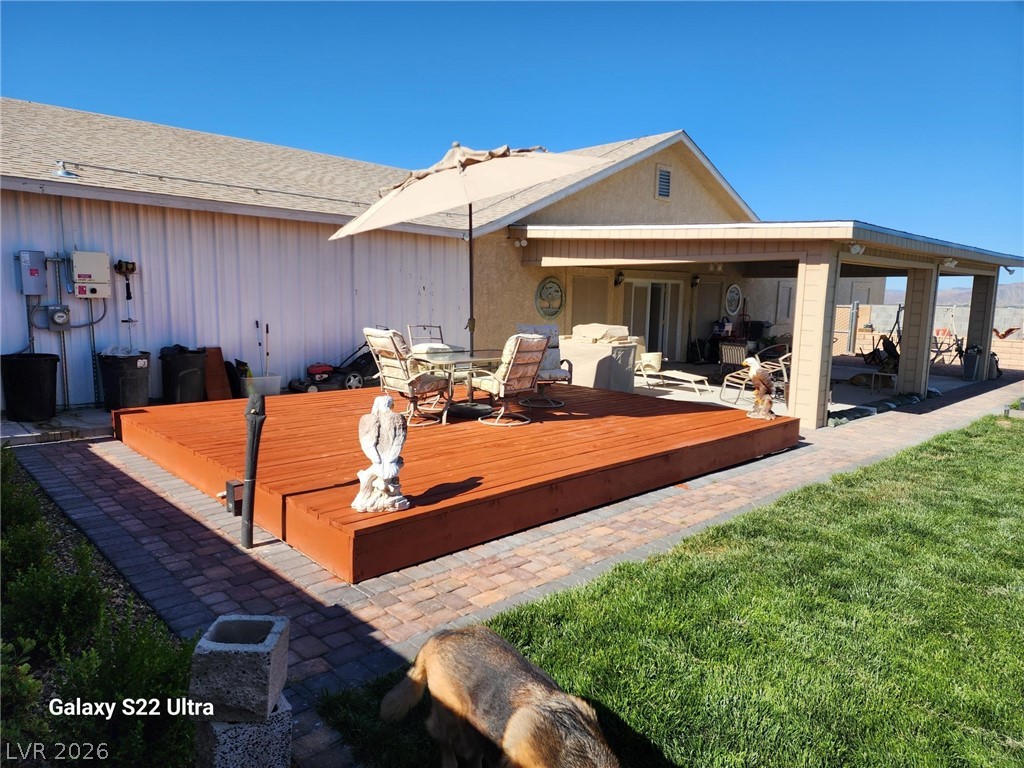 1101 East Blosser Ranch Road Pahrump, NV 89060 - Photo 45 of 50 Rear view of house with a patio area, a wooden deck, outdoor dining space, and a yard