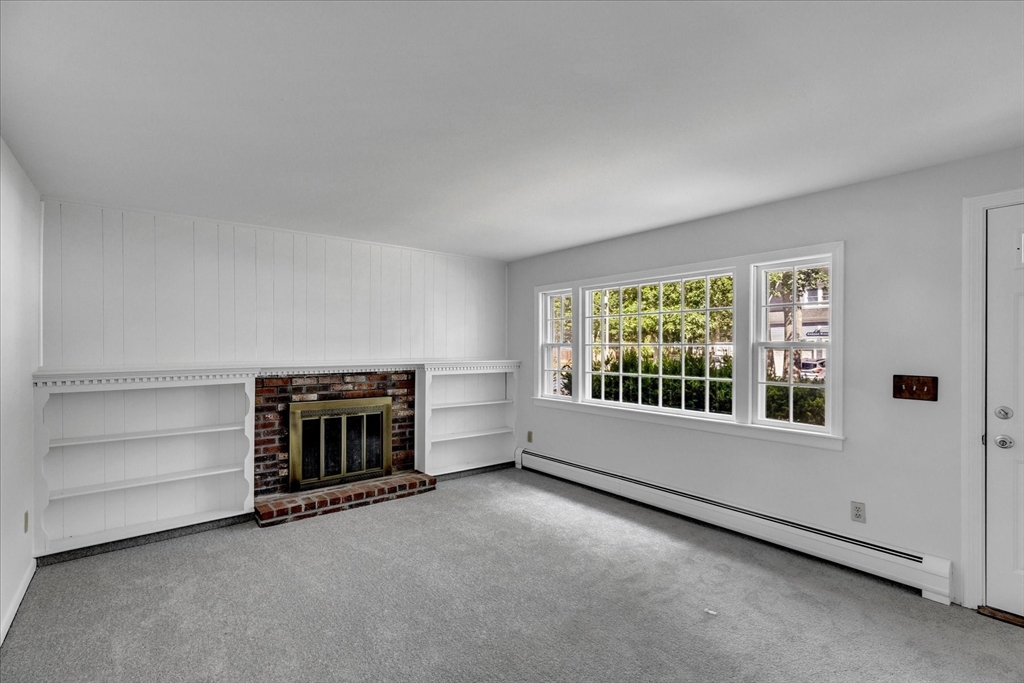 199 Hamden Circle Barnstable, MA 02601 - Photo 2 of 13 an empty room with a fireplace and window