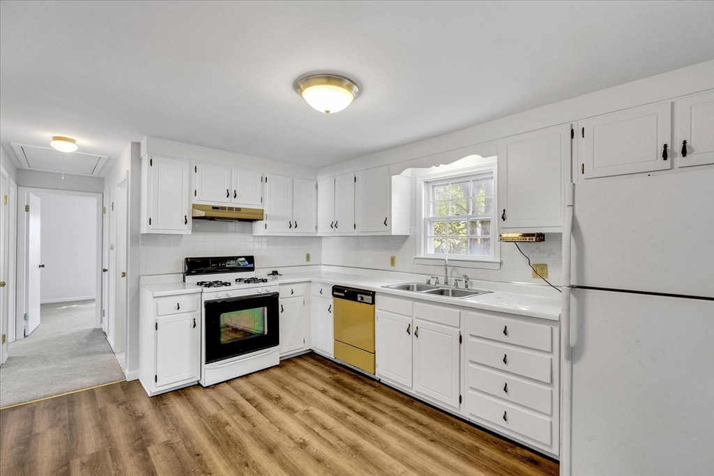 199 Hamden Circle Barnstable, MA 02601 - Photo 4 of 13 a kitchen with stainless steel appliances granite countertop a sink a stove a refrigerator and white cabinets
