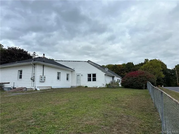 a view of a house with a yard and fence