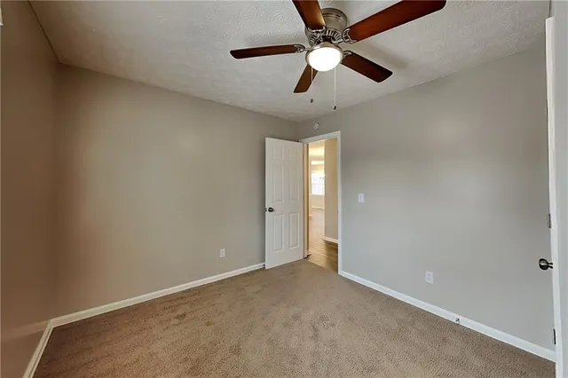 an empty room with chandelier fan