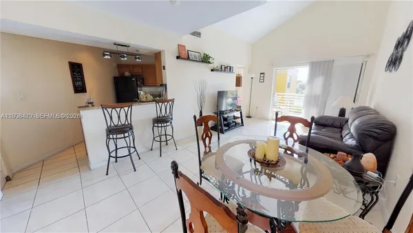 a living room with furniture a flat screen tv and kitchen view