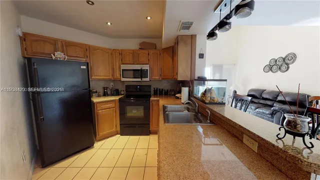 a kitchen with stainless steel appliances a refrigerator sink and stove