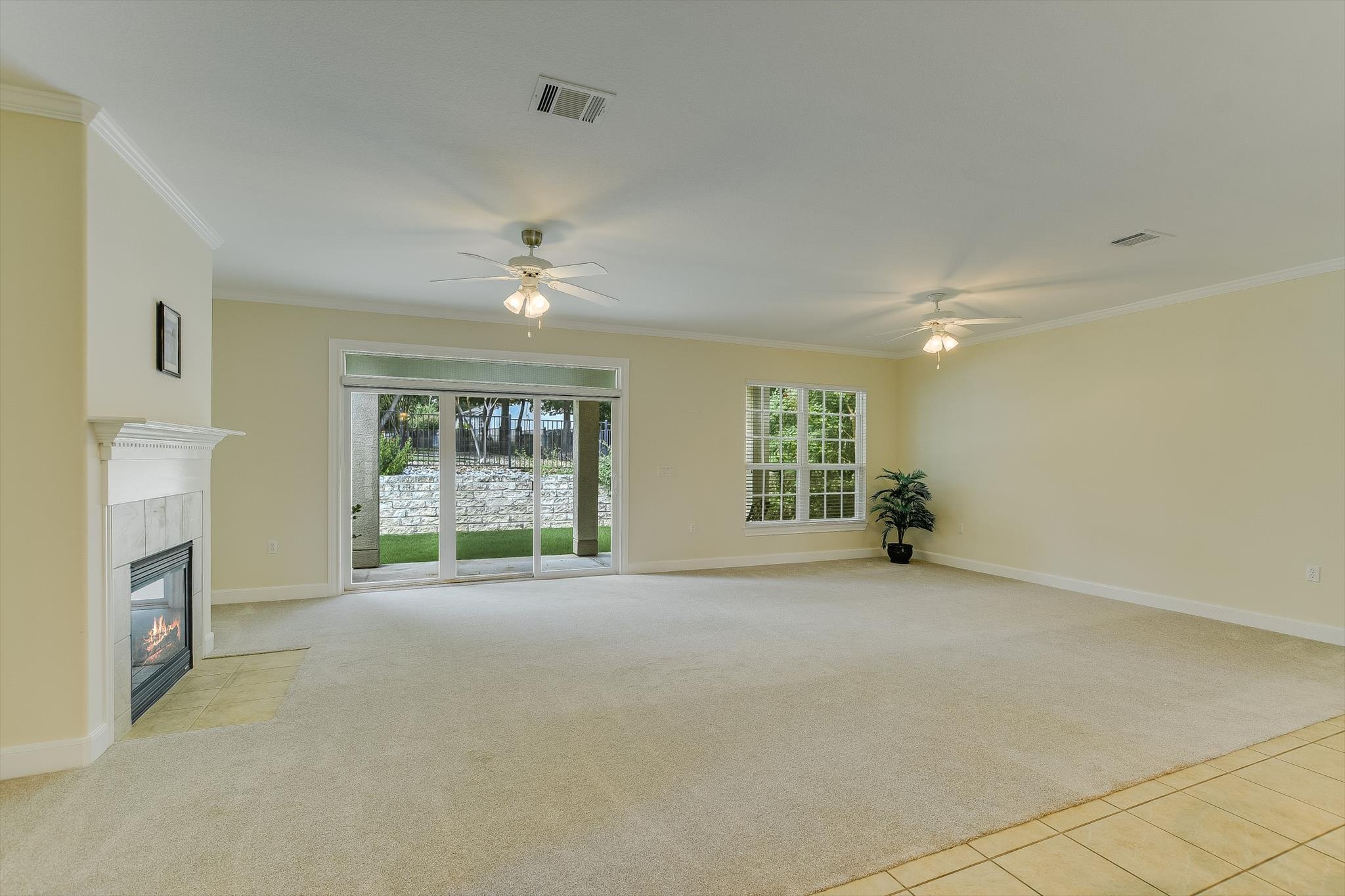 603 Rio Grande Loop Georgetown, TX 78633 - Photo 6 of 27 Unfurnished living room featuring light carpet, plenty of natural light, light tile patterned floors, and ornamental molding