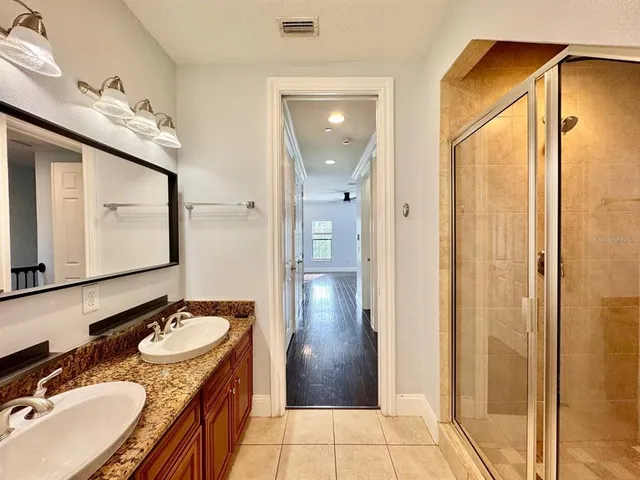 a bathroom with a granite countertop sink double vanity and a mirror