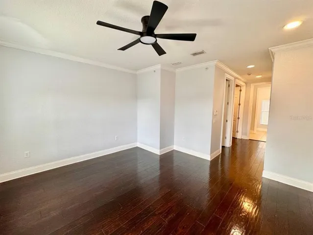 a view of empty room with wooden floor