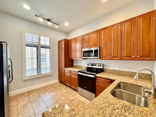 a kitchen with stainless steel appliances granite countertop a stove sink and microwave