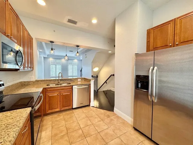 a large kitchen with stainless steel appliances granite countertop a sink and cabinets