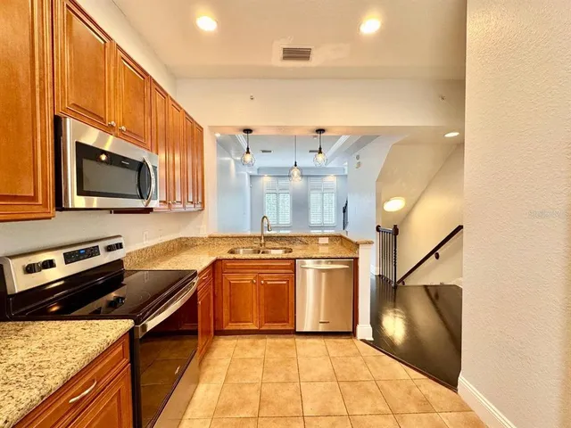 a kitchen with stainless steel appliances granite countertop a sink stove and refrigerator