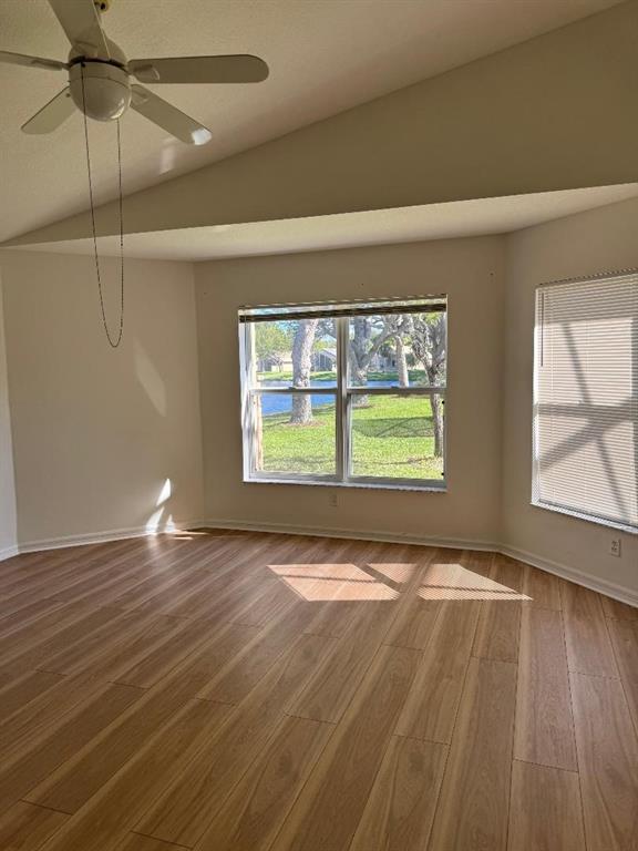 12082 Roma Road Boynton Beach, FL 33437 - Photo 12 of 14 an empty room with wooden floor fan and windows