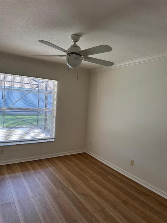 12082 Roma Road Boynton Beach, FL 33437 - Photo 8 of 14 an empty room with wooden floor and windows