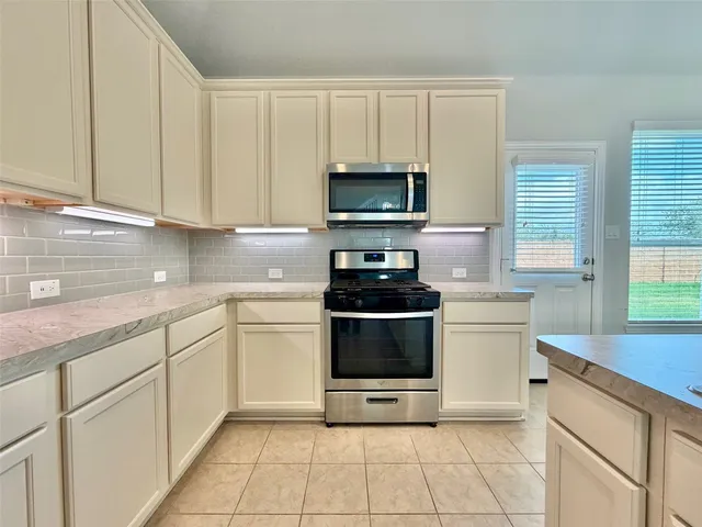 a kitchen with stainless steel appliances granite countertop a sink and a stove