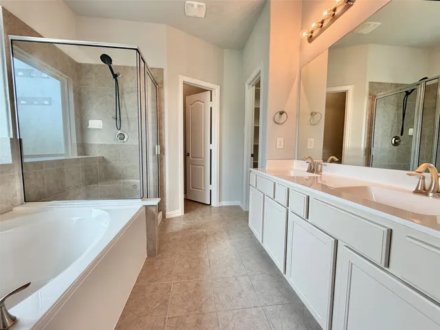 a spacious bathroom with a tub shower sink and mirror