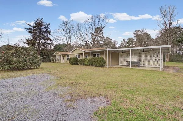 a view of a house with a yard and potted plants