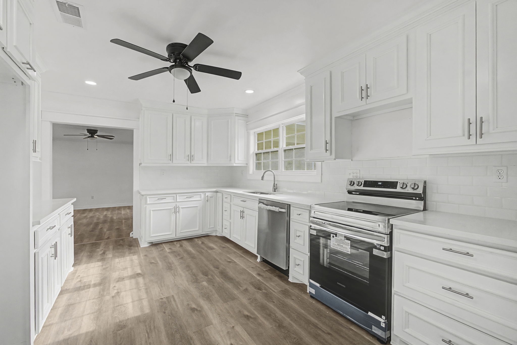 9216 Highway 69 Warren, TX 77664 - Photo 11 of 32 a kitchen with cabinets wooden floor and stainless steel appliances