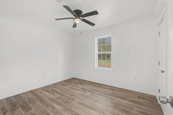 an empty room with a window and a fan