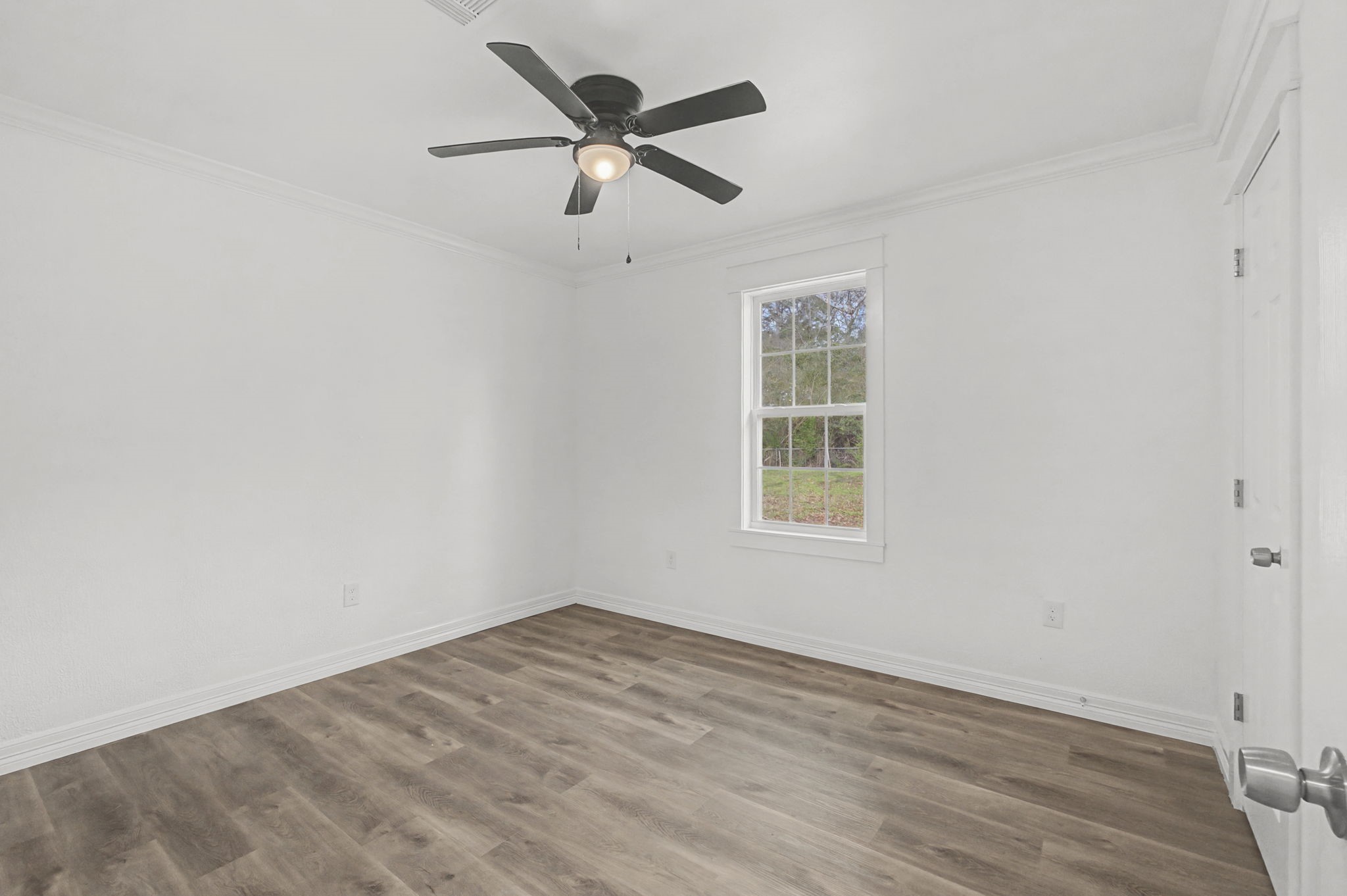 9216 Highway 69 Warren, TX 77664 - Photo 18 of 32 an empty room with a window and a fan