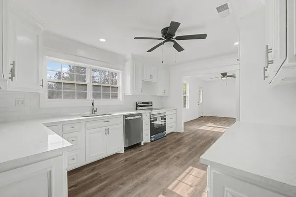 a large kitchen with a stove a sink dishwasher and a refrigerator
