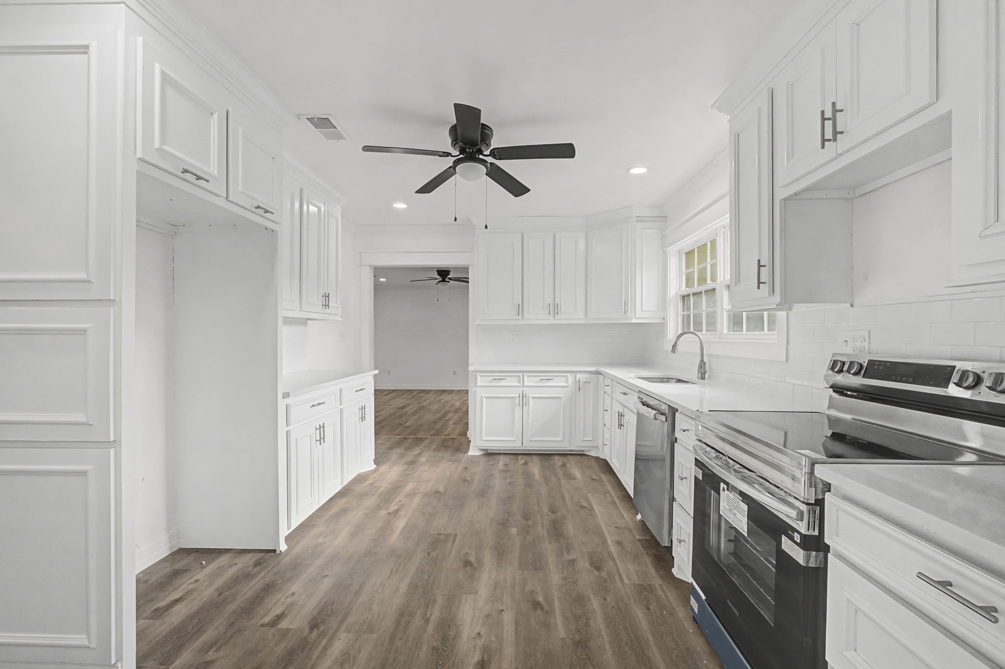 9216 Highway 69 Warren, TX 77664 - Photo 10 of 32 a kitchen with cabinets wooden floor and stainless steel appliances