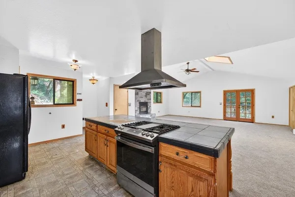 a kitchen with stainless steel appliances granite countertop a stove a sink and a refrigerator