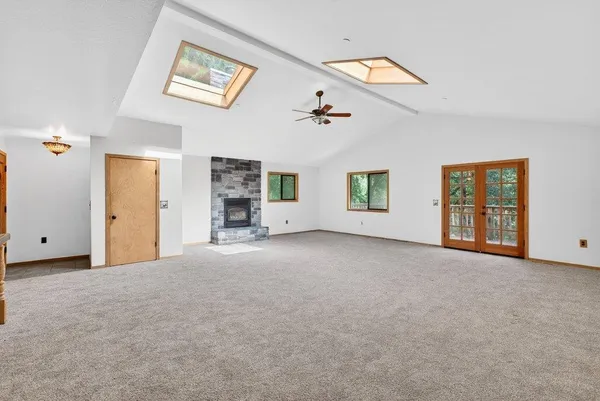 a view of a big room with windows and chandelier fan