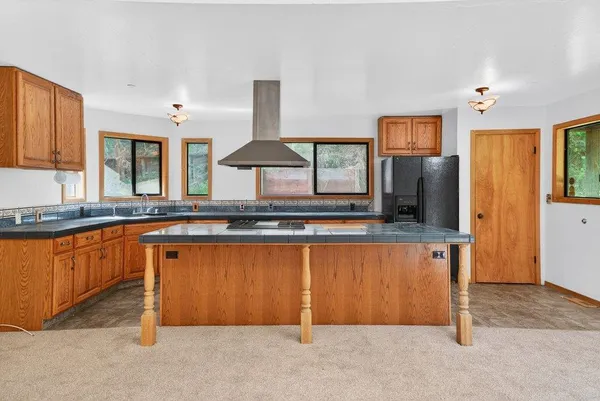 a kitchen with stainless steel appliances granite countertop a stove a sink and a refrigerator