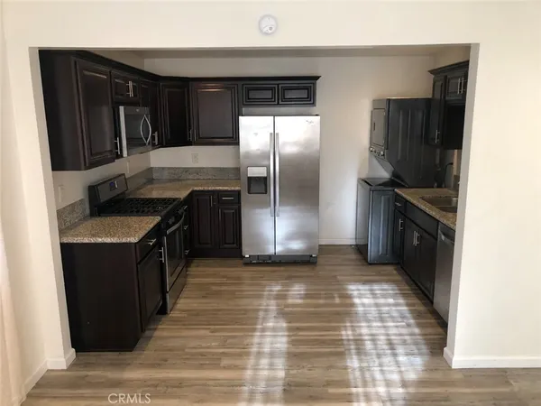 a kitchen with granite countertop a refrigerator and a stove