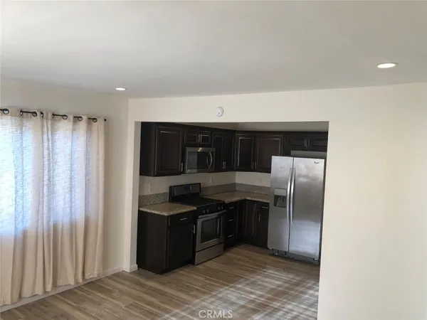 a kitchen with stainless steel appliances granite countertop a refrigerator and a sink