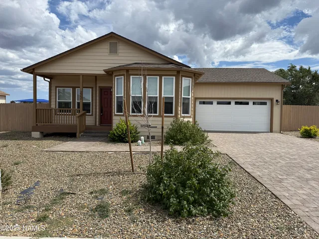 a front view of a house with a yard and potted plants