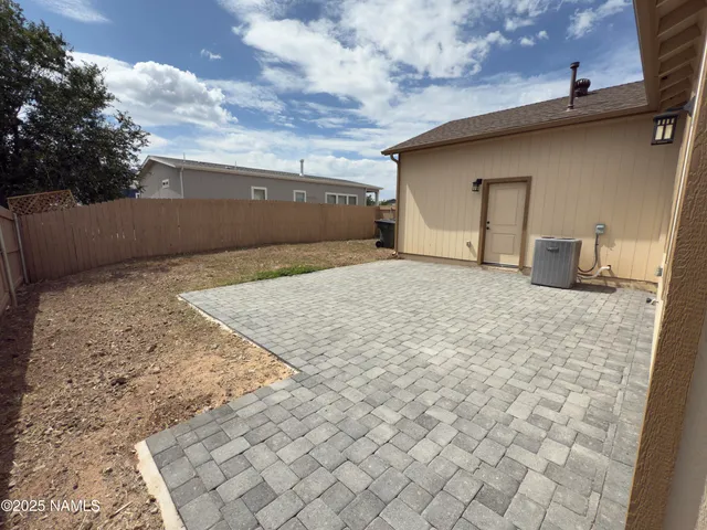 an empty room with wooden floor cabinet and windows