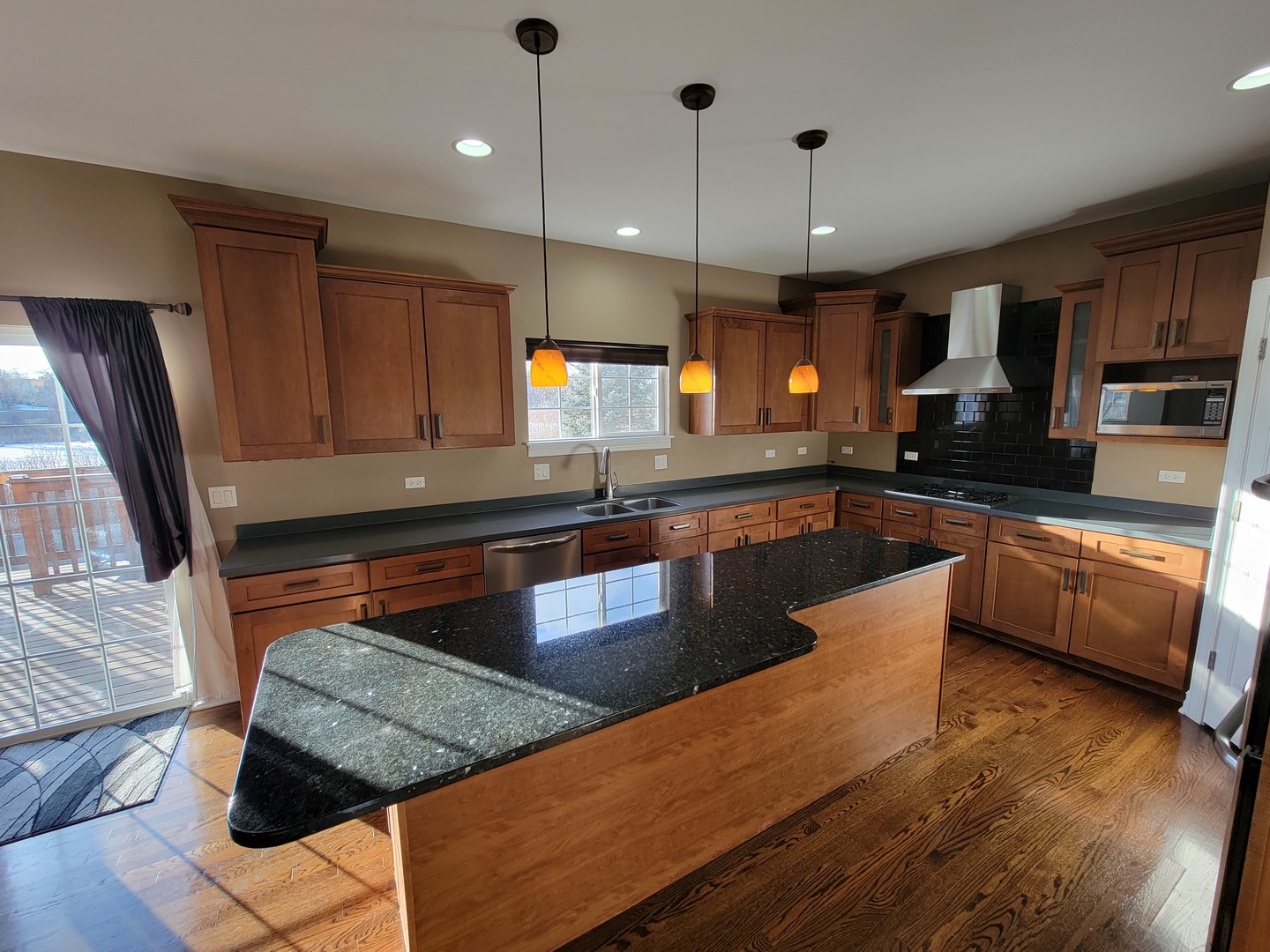 904 Deer Path Drive Antioch, IL 60002 - Photo 13 of 42 a kitchen with stainless steel appliances granite countertop a stove a sink dishwasher a oven a dining table and chairs with wooden floor