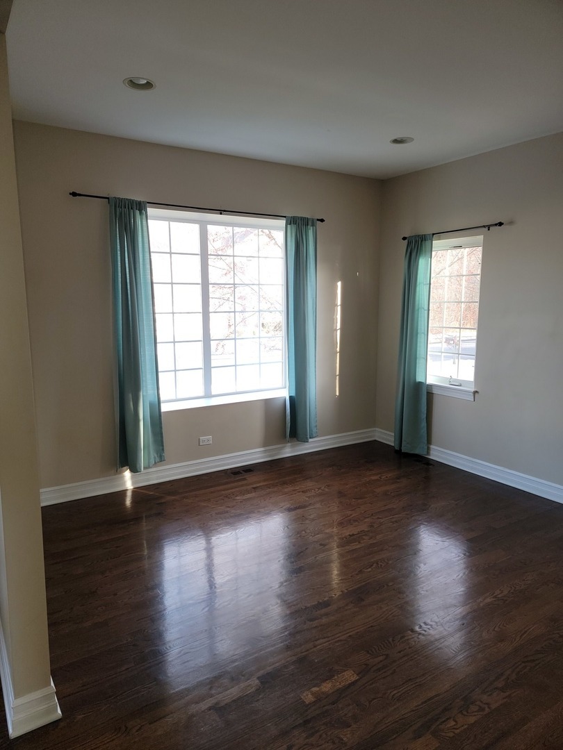 904 Deer Path Drive Antioch, IL 60002 - Photo 7 of 42 a view of an empty room with wooden floor and a window