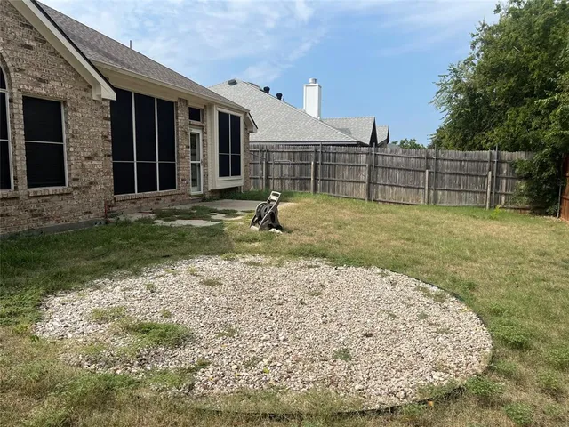 a backyard of a house with wooden fence