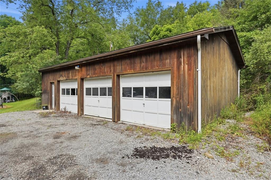 114 Hartzell Road Zelienople, PA 16063 - Photo 5 of 38 3 car garage with concrete floor and shelving