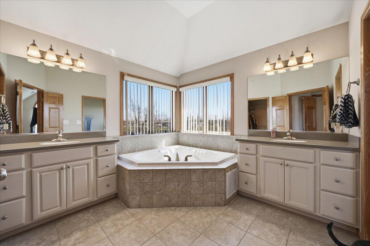 9741 Whitehall Garden Munster, IN 46321 - Photo 20 of 30 a spacious bathroom with a tub a double vanity sink a window and a mirror
