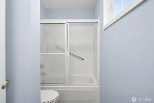 a bathroom with a granite countertop bathtub shower and toilet