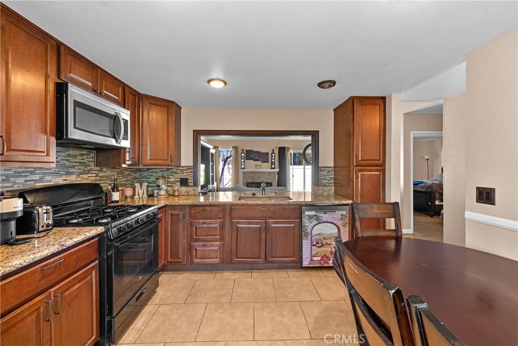a kitchen with stainless steel appliances granite countertop a sink dishwasher stove and refrigerator