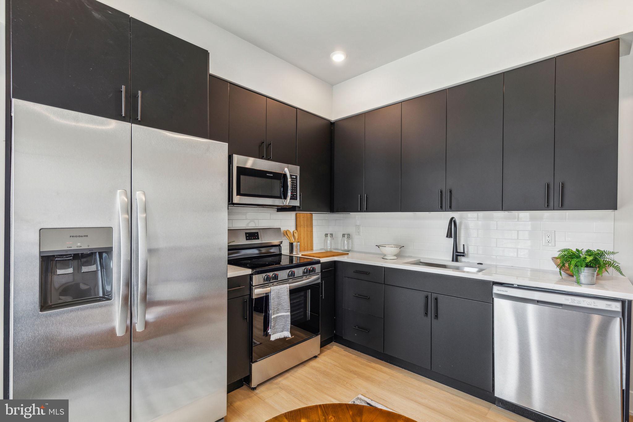 6910 Ridge Avenue, Unit 402 Philadelphia, PA 19128 - Photo 7 of 20 a kitchen with a sink a refrigerator and cabinets