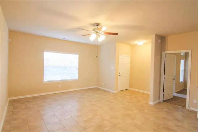 an empty room with closet and a ceiling fan