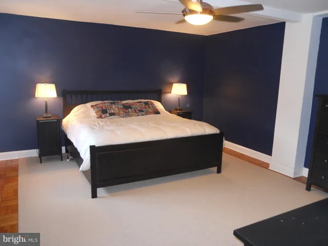 a bed sitting in a bedroom next to a lamp