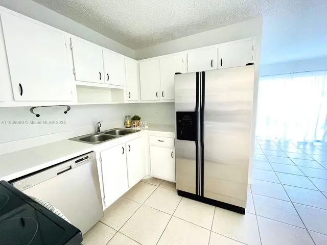 a kitchen with cabinets and a refrigerator