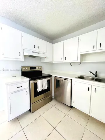 a kitchen with granite countertop white cabinets and white appliances