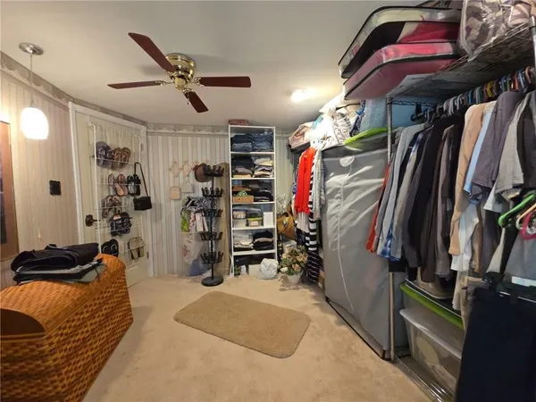 a view of walk in closet with clothes and shoes