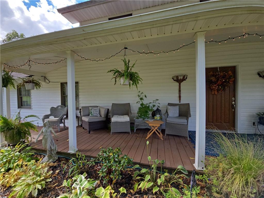1405 Madison Road Templeton, PA 16259 - Photo 46 of 50 a view of a patio with table and chairs potted plants with floor to ceiling window and potted plants